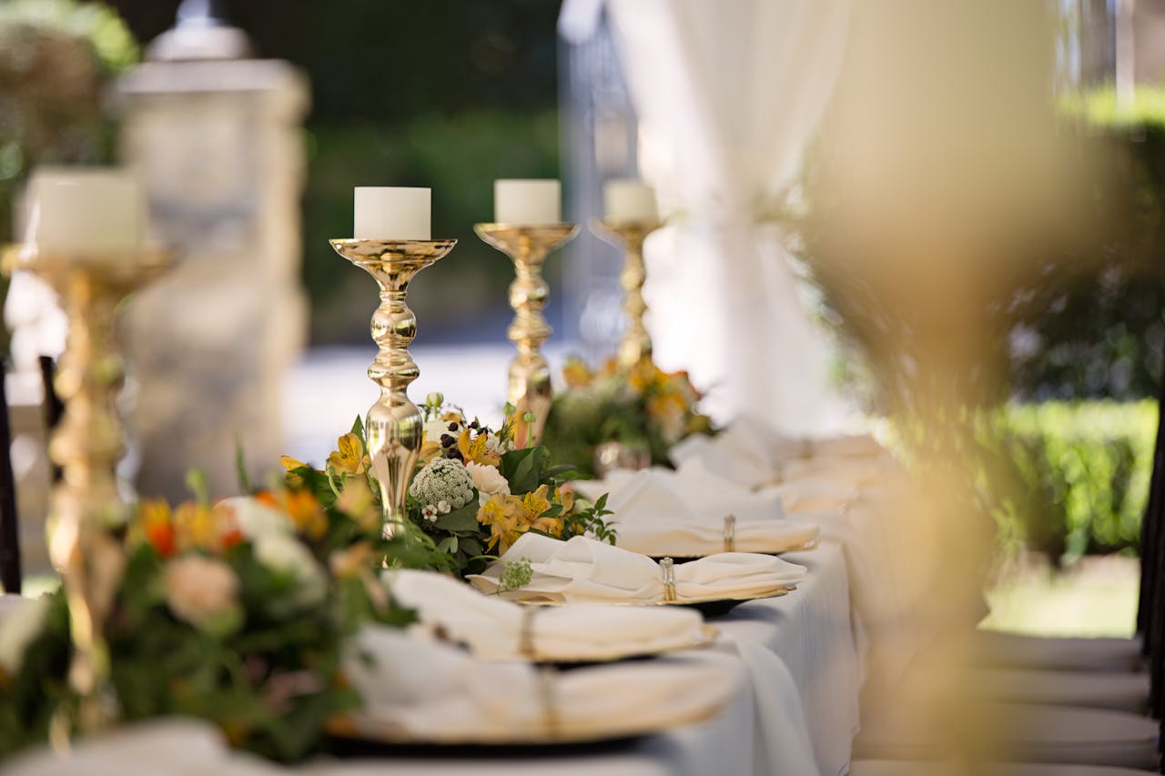 pexels-photo-1128783 Luxurious outdoor wedding table setting with flowers and candlesticks.