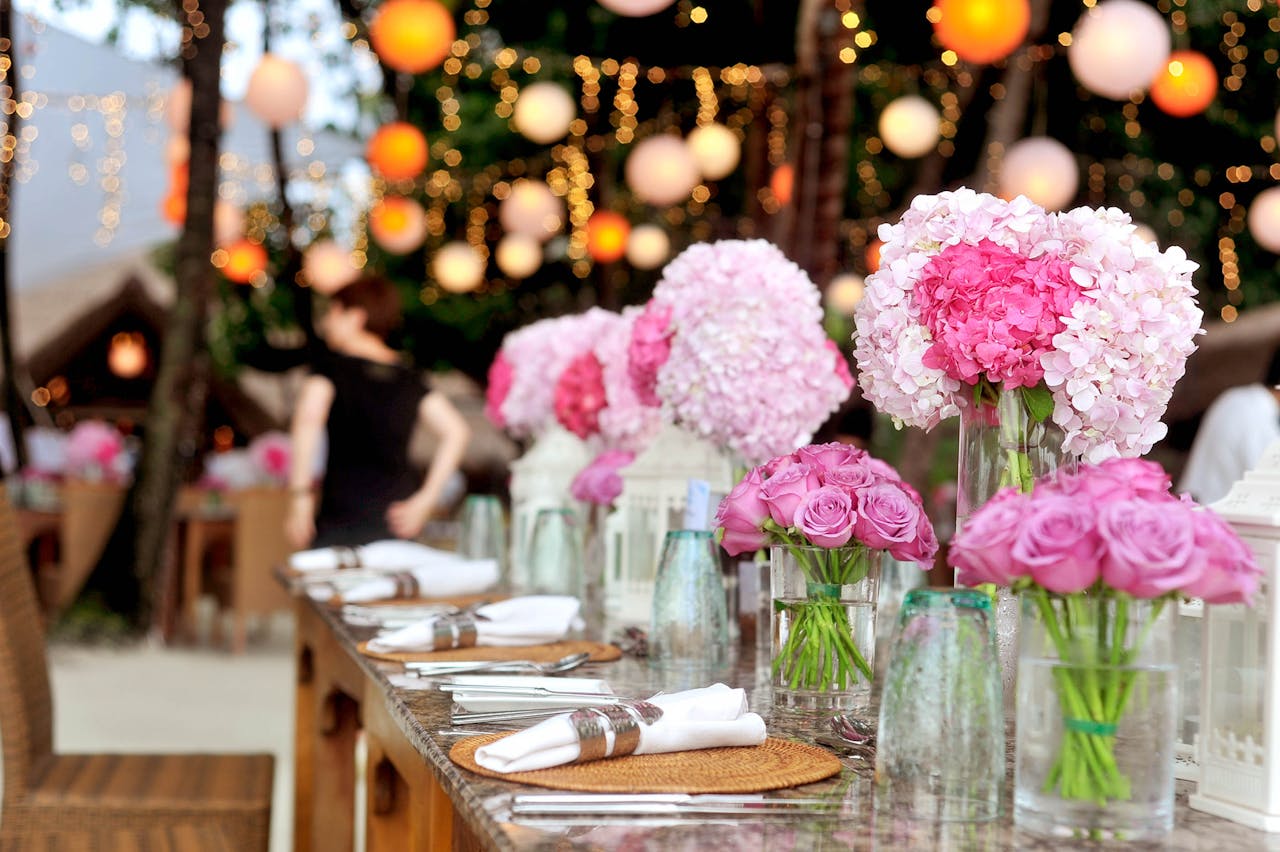 pexels-photo-169190 Elegant outdoor wedding setup featuring pink floral arrangements and soft lighting.